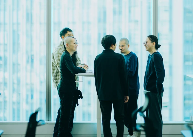 View of SmartHR’s Tokyo headquarters office, with employees smiling in a meeting room by the windows
