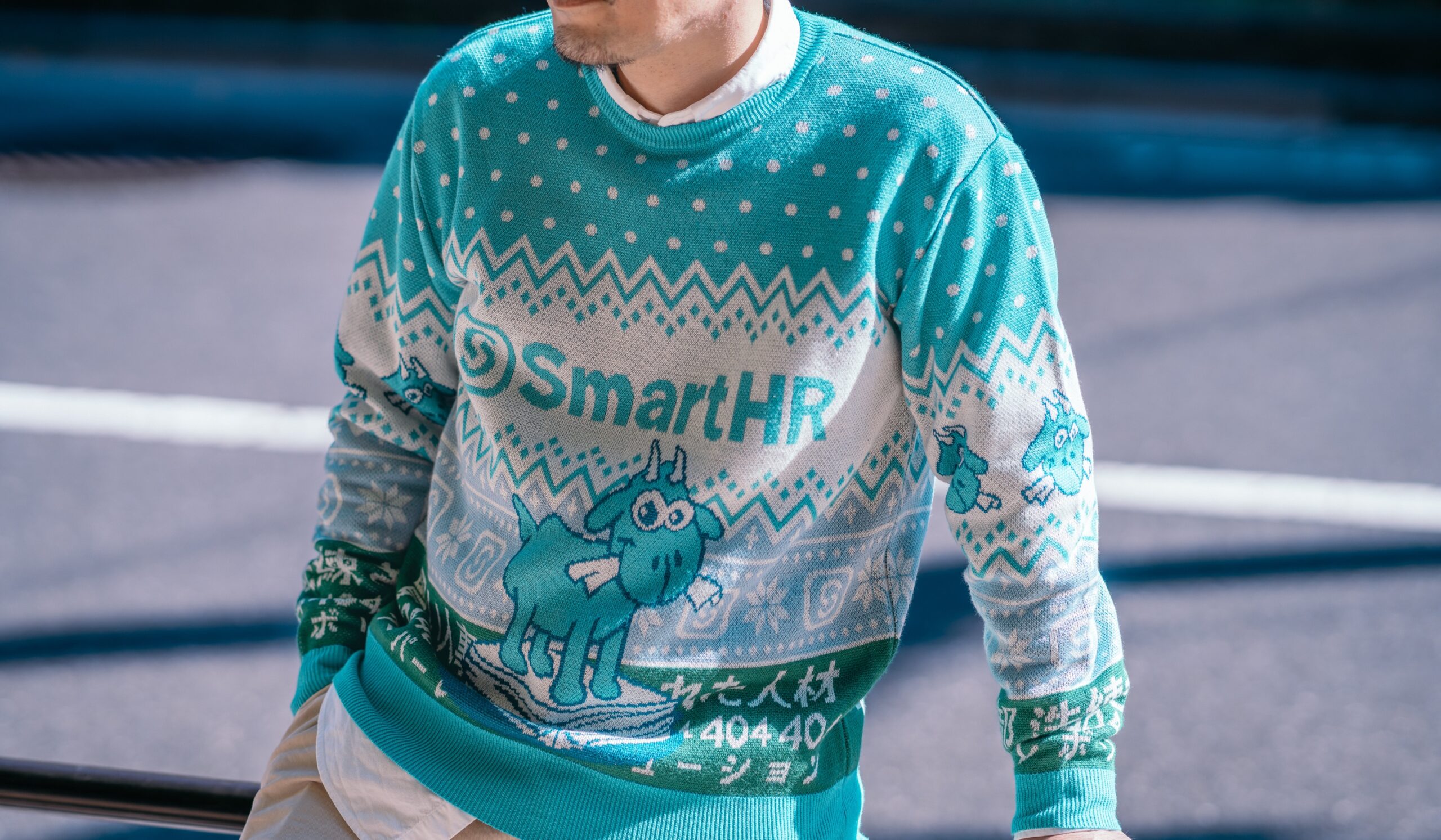 アイキャッチ、SmartHRオリジナルアグリーセーター 「かわいいヤギのセーター」を着用したモデル写真
